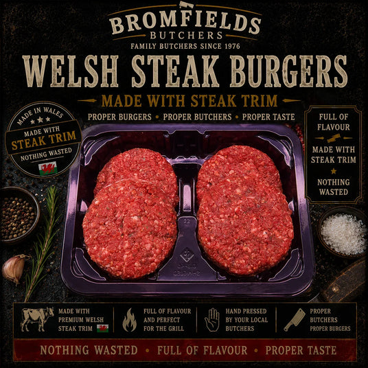 Three Bromfields Burgers Welsh steak burgers in a tray with rosemary, salt, and peppercorns.