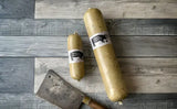 Two sizes of Fruit Pig White Pudding displayed on a rustic wooden surface with a cleaver.