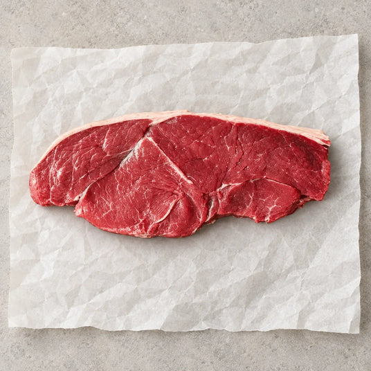 Raw 30oz Caveman Rump Steak by Bromfields Steaks on white parchment paper