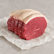 Premium Bromfields Beef topside roasting joint sliced on white parchment paper.