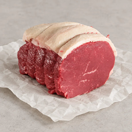 Premium Bromfields Beef topside roasting joint sliced on white parchment paper.